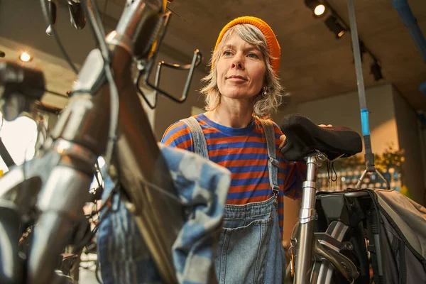 Fokuserad Kvinna Cykel Mekaniker Undersöka Och Reparera Cykel Verkstad Koncept — Stockfoto