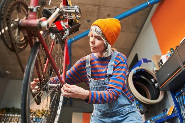 Χαμηλή Γωνία Άποψη Της Περιποιητικής Γυναίκα Τοποθέτηση Εξαρτημάτων Ποδηλάτων Για — Φωτογραφία Αρχείου
