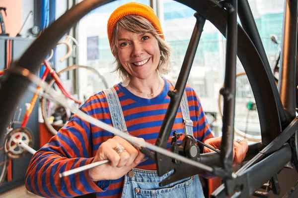 Χαρούμενη Κυρία Ποδήλατο Μηχανικός Έλεγχο Τροχό Ποδήλατο Μίλησε Στο Εργαστήριο — Φωτογραφία Αρχείου