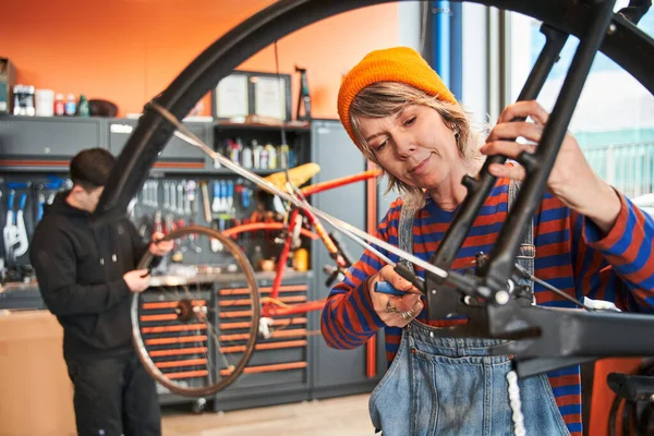 Mecánica Ciclista Femenina Que Fija Rueda Bicicleta Mientras Que Colega — Foto de Stock