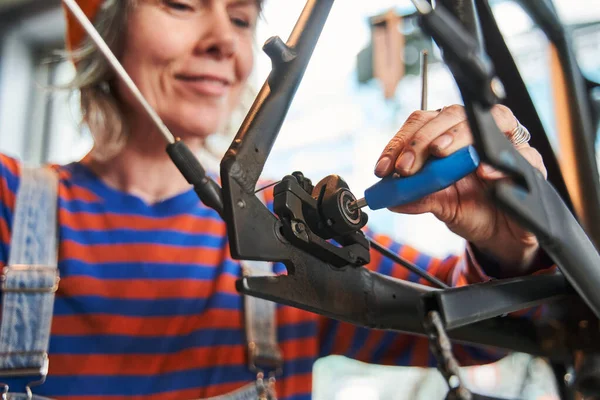 Vista Recortada Positiva Mujer Caucásica Trabajadora Reparando Rueda Bicicleta Mientras — Foto de Stock