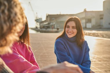 Güneşli caddede konuşurken mutlu adama bakan kadının portresi. Birlikte vakit geçiriyorlar.