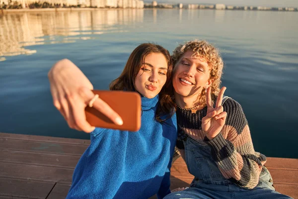 Positiva Tonåring Par Gestikulerande Händer Och Mobiltelefon Selfie Vid Den — Stockfoto
