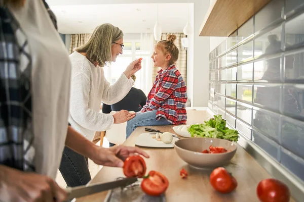 Glückliche Seniorin Mit Brille Füttert Ihre Enkelin Während Sie Die — Stockfoto