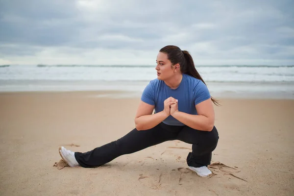 Kasvetli Okyanus Sahilinde Bacaklarını Esneten Sportif Eşofmanlı Beyaz Kadın Ayrıca — Stok fotoğraf