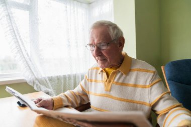 Evde gazete okuyan bir emekli, sıradan bir hizmetçi. Yüzüncü yüzyılın kavramı.