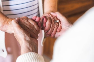 Yaşlı çiftin elleri birbirine sıkıca tutunur..