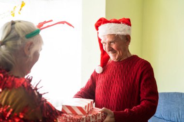 Mutlu emekliler Noel 'i dekore edilmiş bir evin önünde kutluyor. Birlikte mutluyuz, asırlardır..