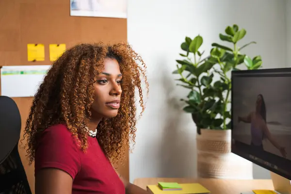 African american curly woman staring at computer screen and feeling focused at workplace. People and technologies concept