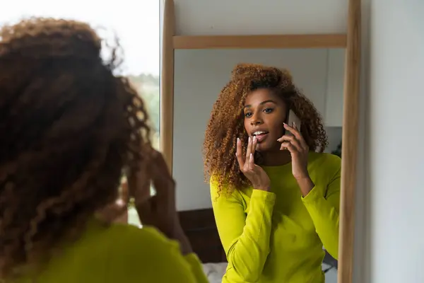 Göndör Afro Amerikai Hívja Mobilját Nézi Tükröt Miközben Otthon Van Jogdíjmentes Stock Képek