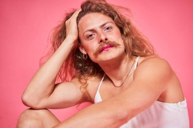 Pembe duvar arkasında makyaj yapmış güzel bir gencin stüdyo portresi. Yaratıcı görünüm kavramı