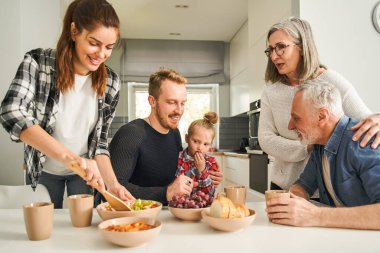 Çok nesildir aile, hafif mutfakta birlikte kahvaltı hazırlıyor. Mutlu insanlar yaşam tarzı konsepti. Stok fotoğrafı