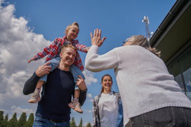 Çekici, neşeli bir ailenin portresi. Açık havada boş vakit geçirirken kız çocuğuyla eğleniyor ve oynuyor.