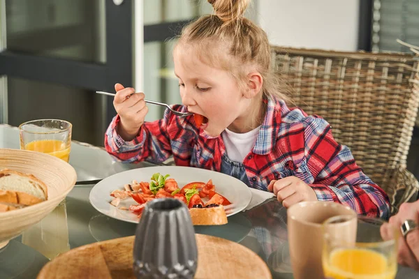 Fokuserad Barn Flicka Hålla Gaffel Och Äta Med Aptit Samtidigt Stockbild