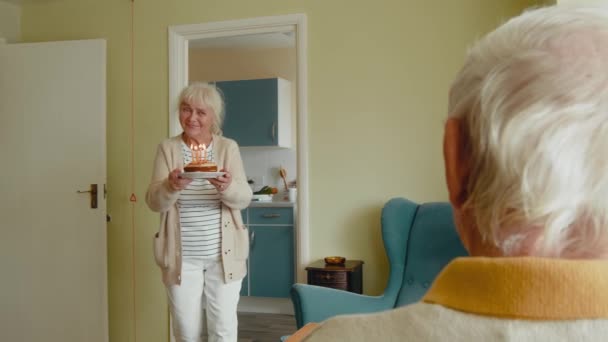 誕生日ケーキで記念日を祝う美しいシニアカップル 自宅で誕生日パーティーをする高齢カップル — ストック動画