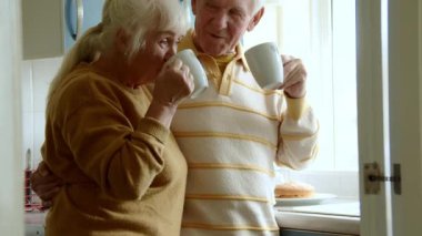 Mutlu kıdemli adam sabah karısıyla çay içiyor. Emekliliğe kucak açan sevgi dolu çift birlikte vakit geçiriyorlar.