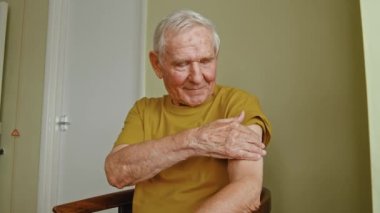 Sorumlu beyaz, orta yaşlı bir adam aşıdan sonra koluna bantla bakıyor. Tıp konsepti