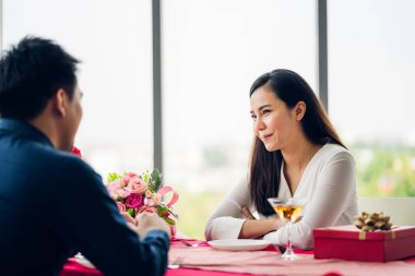 Sevgililer Günü 'nü birlikte kutlarken eğlenen ve gülümseyen romantik çift. Sevgililer Günü' nde kız arkadaşına hediye paketi veren yakışıklı adam.