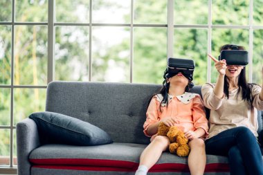 Mutlu aşk portresi Asyalı anne ve Asyalı kız çocuk gülümsüyor ve sanal gerçeklik gözlüğü kullanarak eğleniyorlar. Modern VR metaverse teknolojisi kavramı.