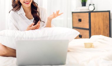 Kadın konuşması, dizüstü bilgisayarın çalışması ve evdeki iş arkadaşlarıyla çevrimiçi video konferansı kullanarak konuşuyor. Yaratıcı kadın, ev konseptinden iş ekibiyle görüntülü konuşma görüşmesi yapıyor.