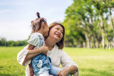 Mutlu aşk portresi Asyalı büyükanne ve Asyalı küçük tatlı kız yaz parkında rahatlayın. Gülen büyükanneleri ve büyükbabalarıyla birlikte gülümseyen genç kız. Aile ve beraberlik.
