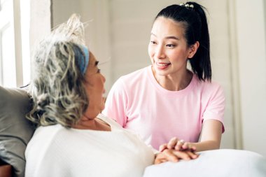 Mutlu bir aşk portresi. Asyalı mutlu bir aile. Yaşlı, olgun bir anne ve genç bir kız. Gülümseyen, kucaklayan ve kucaklayan.