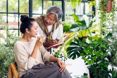 Mutlu bahçıvan yaşlı bir çift bahçedeki küçük ağaçlara bakıyorlar. Emeklilik konsepti.