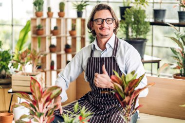 Mutlu bahçıvan kıdemli yaşlı adam bahçedeki küçük ağaçla ilgilenen çiçek sulama ve bahçeyle bahçeye bakıyor. Emeklilik kavramı.