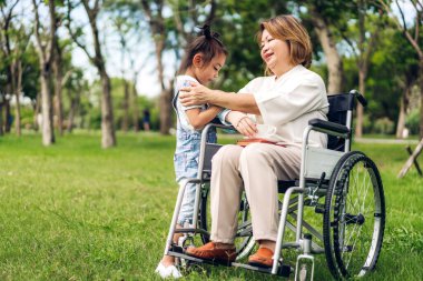 Mutlu aşk portresi Asyalı büyükanne ve küçük tatlı Asyalı kız yaz parkında rahatlayın. Büyük anne ve babası birlikte gülümseyen genç kız. Aile ve beraberlik.