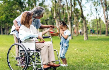 Mutlu aşk portresi Asyalı büyükbaba ve büyükannesi ve Asyalı küçük tatlı kız yaz parkında rahatlayın. Gülen büyükannesi ve büyükbabası birlikte gülümseyen genç kız. Aile ve beraberlik.