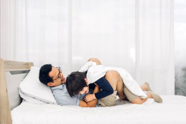 Mutlu bir aşk portresi. Asyalı bir aile babası. Küçük Asyalı bir oğlan çocuğu taşıyor.