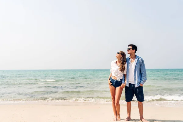 休暇ロマンチックな愛若い幸せな笑顔のカップル新婚旅行の休暇旅行で一緒に熱帯のビーチで楽しくリラックスしている青い空の海のビーチで砂の上に立つ夏の旅行 — ストック写真