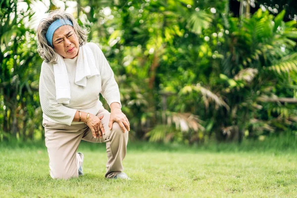 体弱多病的老年亚洲老年妇女 摸着她的肌肉受伤的腿 在家里的公园里感到肌肉膝痛 身体受伤和健康问题 — 图库照片