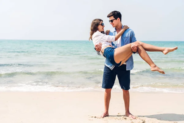 休暇ロマンチックな愛若い幸せな笑顔のカップル新婚旅行の休暇旅行で一緒に熱帯のビーチで楽しくリラックスしている青い空の海のビーチで砂の上に立つ夏の旅行 — ストック写真