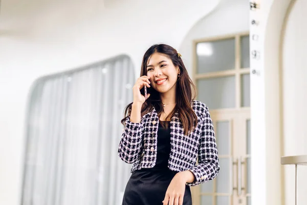 Portrait of smiling happy beauty asian business woman relaxing using digital technology smartphone.Young asian girl work call and talk with friend business team at city