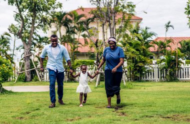 Mutlu aşk portresi Afro-Amerikan aile Afrikalı baba ve anne ve küçük Afrikalı kız çocuk gülümseyerek ve evde iyi vakit geçirerek eğleniyorlar.