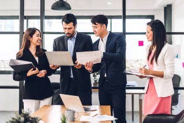 Asya iş toplantıları ve strateji projesi analizi finans süreci tartışmaları. İş adamları planlarını ve pazarlama fikirlerini ofiste dizüstü bilgisayarla işlerler. Takım çalışması