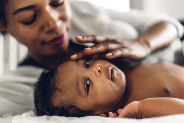 幸せな愛の家族の肖像画アフリカ系アメリカ人の母親は愛らしい小さなアフリカ系アメリカ人の赤ちゃんと遊んでいます お母さんは白い寝室で楽しい時間をかわいい息子の瞬間とキス 黒人家族の愛 — ストック写真