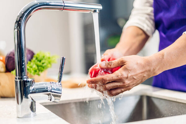 Портрет человека шеф-повара приготовления пищи и подготовки мыть свежие овощи салат брызг в воду с приготовлением пищи на прилавок стоя в ресторане коммерческой кухни