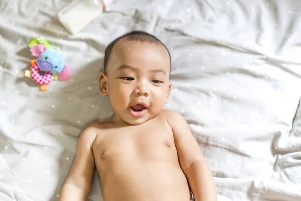 Portrait of happy smile asian baby boy relaxing looking at camera.Cute asian newborn child on the bed at home