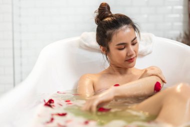 Mutlu, güzel Asyalı güzel bir kadının portresi temiz, sağlıklı, beyaz bir cilt spa tedavisiyle rahatlamanın ve banyo yaparken banyo köpüklü spa ile banyo yapmanın keyfini çıkar.