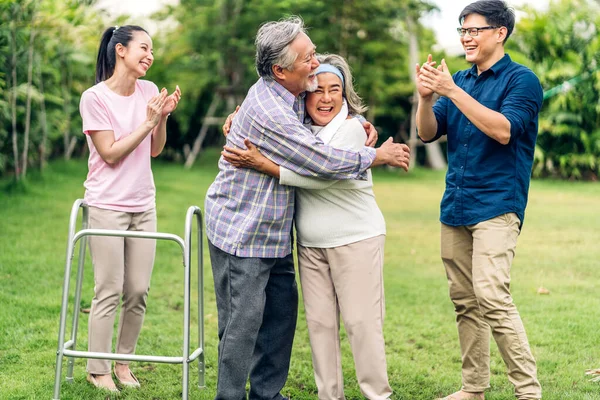 Portre, mutlu, gülümseyen, çok nesildir gülümseyen Asyalı büyük kucaklama ailesinin keyfini çıkarın. Yaşlı bir baba ve yaşlı bir anne ve genç bir kadın ve oğlu ile birlikte evde park halinde. Sigorta kavramı.