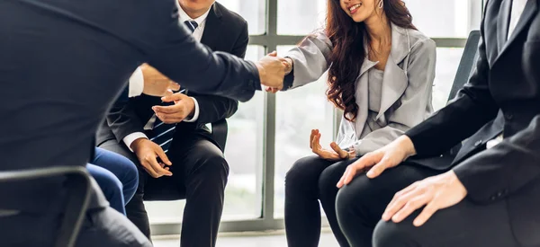 在现代办公室里 两个穿着雅致西装的亚洲商业伙伴在一群随意拍手的同事面前成功地握手 — 图库照片