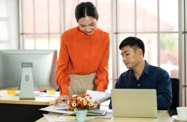 Asyalı iş adamı ve kadın yeni başlayan projeyle strateji analizi ve tartışması. Yaratıcı iş adamları ofiste plan yapar ve beyin fırtınası yapar. Takım çalışması.