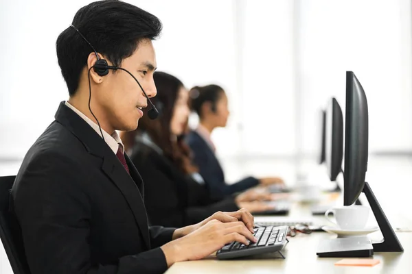 一组快乐的呼叫中心微笑的经营者顾客帮助支持呼叫中心办公室在台式计算机上与耳机一起工作和交谈的团队电话服务 — 图库照片