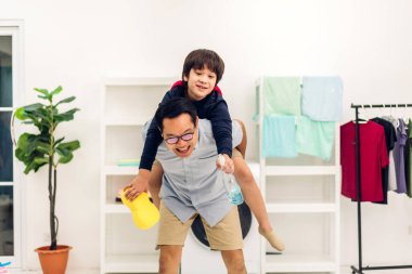 Mutlu bir aşk portresi. Asyalı bir aile babası. Küçük Asyalı bir oğlan çocuğu taşıyor.