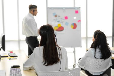 Mutlu çağrı merkezi gülümseyen işletme operatörü grubu çağrı merkezindeki masaüstü bilgisayarında çalışan ve kulaklıkla konuşan ekip telefon hizmetlerini desteklemeye yardımcı olur.