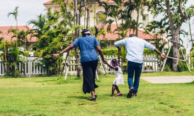 Mutlu aşk portresi Afro-Amerikan ailesi Afrikalı baba ve anne ve küçük Afrikalı kız çocuğu gülümseyerek eğleniyor ve evde eğleniyor.