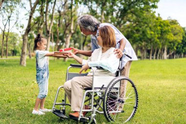 Mutlu aşk portresi Asyalı büyükbaba ve büyükannesi ve Asyalı küçük tatlı kız yaz parkında rahatlayın. Gülen büyükannesi ve büyükbabası birlikte gülümseyen genç kız. Aile ve beraberlik.