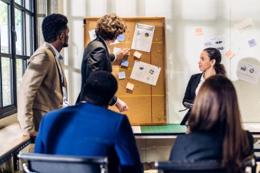 Girişim proje analizi finans süreci ile bir grup iş toplantısı ve strateji tartışması. İş adamları ofiste belge ile pazarlama fikrini planlar ve beyin fırtınası yaparlar. Takım çalışması